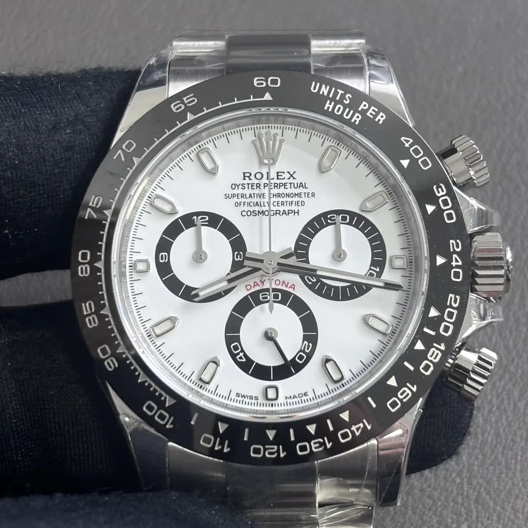 A Daytona with a white dial and black ceramic bezel, photographed from the front; the watch carries the serial 6W06K603